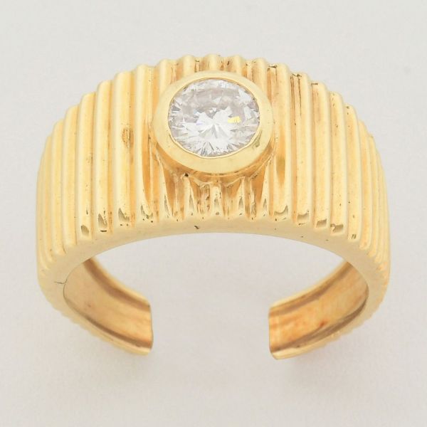 Anel em ouro amarelo 18 k, modelo canelado, trabalhado com frisos verticais, com diamante solitário de aproximadamente 0,50 ct. Aro aberto. Peso total 5,2 g.