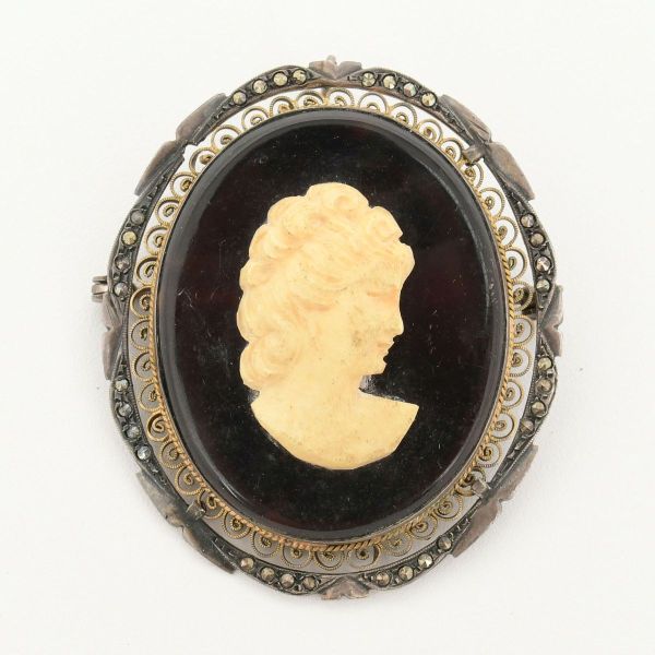 Broche pendente camafeu, em moldura em vermeil, representando silhueta clássica de mulher, associada ao estilo art nouveau, medidndo 53 x 45 mm.