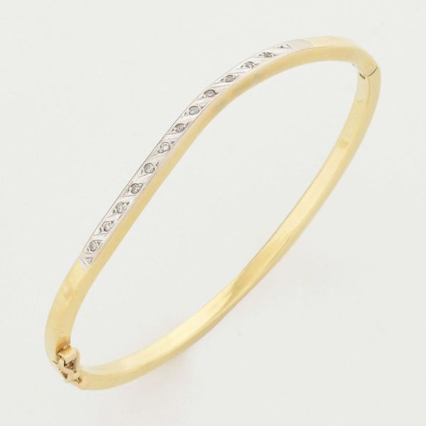 Pulseira escrava em ouro amarelo 18 k, tendo em sua parte principal dezoito diamantes. Medida interna 5,6 x 4,9 cm. Peso total 9,0 g.