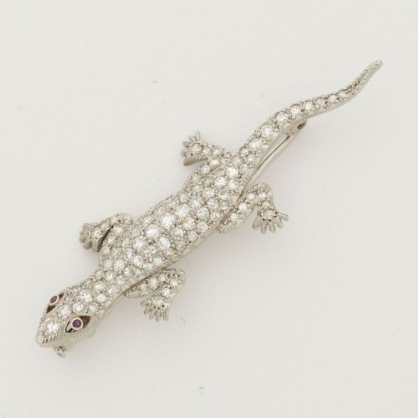 Broche em platina, com pavê de diamantes e olhos em rubis, em formato de salamandra. Comprimento 50 mm. Largura 15 mm. Peso 6,2 g.