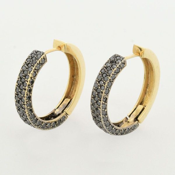 Par de brincos em ouro amarelo 18 k 720, modelo argolas, cravejadas com diamantes negros. Diâmetro 25 mm. Peso total 9,1 g.