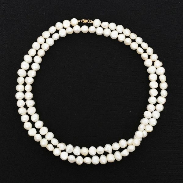 Colar de uma volta com pérolas irregulares, medindo aprox 85,0 cm. Fecho em ouro amarelo 18 k. Peso total 76,0 g.