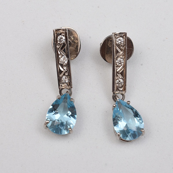 Par de brincos em ouro branco 18 k, com seis diamantes de aproximadamente 0,01 ct cada, finalizados com dois topázios azuis Sky Blue, lapidação gota de aprox 2,40 ct no total. Comprimento 22 mm. Peso