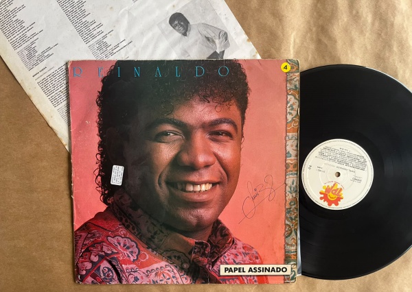LP: Artista: Reinaldo / Album: Papel assinado | Selo: TPM | Cód: 511 663-1Capa (VG -): Muito Bom: marcas superficiais, com detalhes visuais; pode conter leve rasura como um nome; leve depreciação de V
