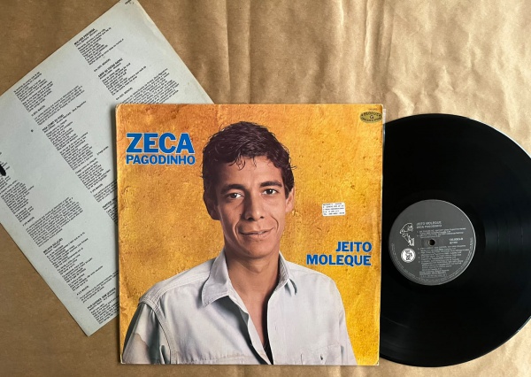 LP: Artista: Zeca Pagodinho / Album: Jeito Moleque | Selo: RCA | Cód: 130 0053Capa (VG): Muito Bom: marcas superficiais, com detalhes visuais; pode conter leve rasura como um nome. Vinil (VG +): Vinil