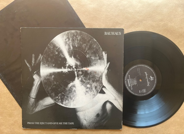 LP: Artista: Bauhaus / Album: Press the eject and give me the tape | Selo: Virgin | Cód: 70216Capa (VG): Muito Bom: marcas superficiais, com detalhes visuais; pode conter leve rasura como um nome. Vin