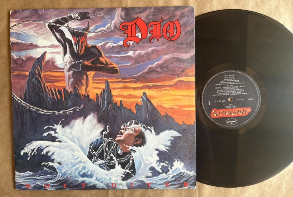 LP: Artista: Dio / Album: Holy Diver | Selo: Mercury | Cód: 811 021Capa (VG): Muito Bom: marcas superficiais, com detalhes visuais; pode conter leve rasura como um nome. Vinil (VG +): Vinil em muito b