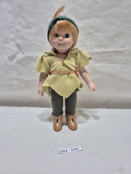 Boneca vintage de porcelana do personagem Peter Pan com roupas de feltro e chapéu com pena. Medindo 18cm de altura.