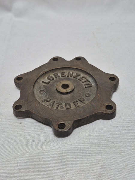 Antiga tampa pesada em bronze da marca Lorenzetti. Medindo 11,5cm de diâmetro.