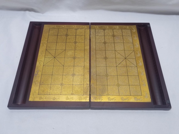 Tabuleiro de xadrez chines dobrável com tampo de vestido de metal dourado com relevos. Medindo fechado 30cm x 20cm x 3,5cm de altura.