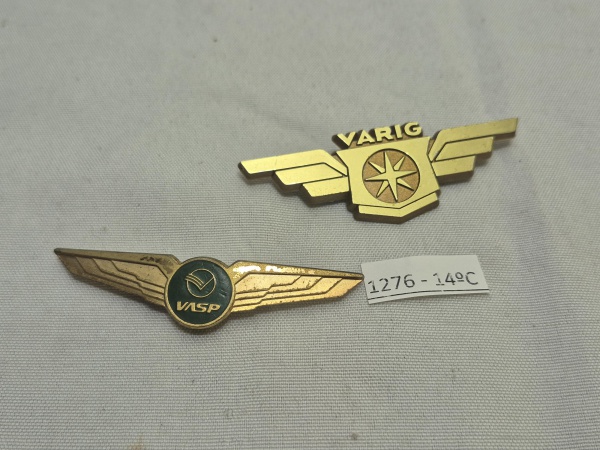 Lote de 2 broches, insígnias asa de piloto, sendo um da extinta cias aéreas Vasp em metal dourado e da Varig em plástico duro, produto original. Medindo 7cm.