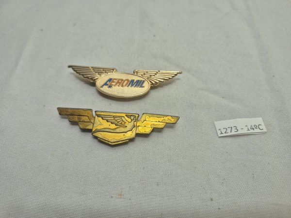 Lote de 2 broches, insignias - asas de piloto da extinta cia aérea Varig (Pegasus) e da Aeromil, em metal dourado. Medindo 7cm.
