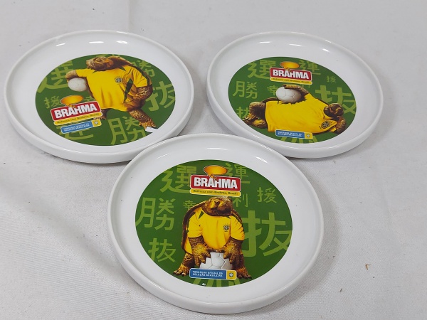 Lote de 3 petisqueiras redondas em melanina com estampa da Bhrama "Torcedor oficial da seleção brasileira". Medindo 14,5cm de diâmetro.