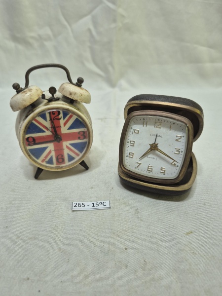 Conjunto de 2 relógios de mesa vintage, sendo um despertador de corda com estampa da bandeira do Reino Unido (Union Jack) no mostrador e um relógio de viagem Europa de 2 rubis em estojo dobrável de co