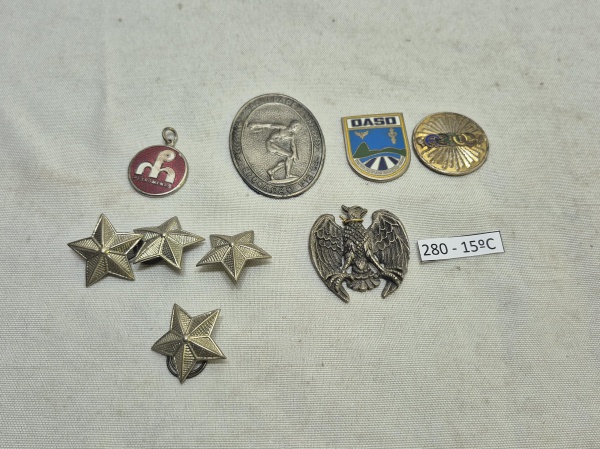 Conjunto com 9 itens de metal, incluindo 4 estrelas prateadas, um brasão de águia, um pingente da Petrominas e medalhas temáticas de educação física e aviação.Medindo 4cm x 3,5cm.