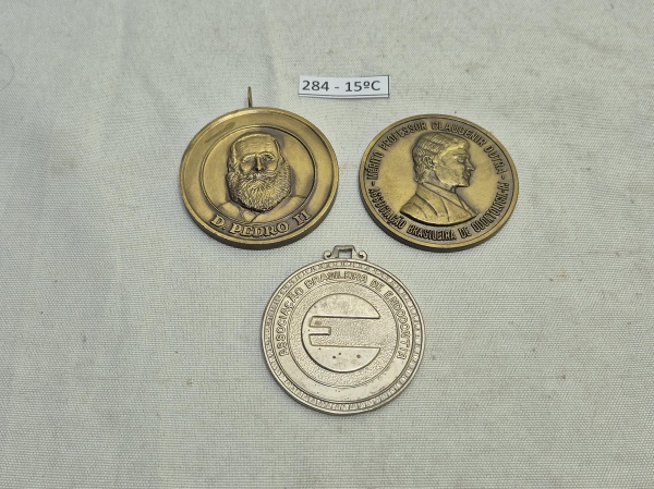 Conjunto de 3 medalhas comemorativas em bronze e metal prateado, incluindo peças da Academia de Odontologia do Rio de Janeiro (D. Pedro II), Mérito Professor Claudenir Dutra (1989) e 25 anos da Associ