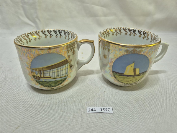 Lote de 2 xícaras em porcelana Steatita com acabamento dourado e estampas do Palácio da Alvorada e da Capela do Palácio da Alvorada em Brasília. Medindo 8cm x 7,5cm de altura.
