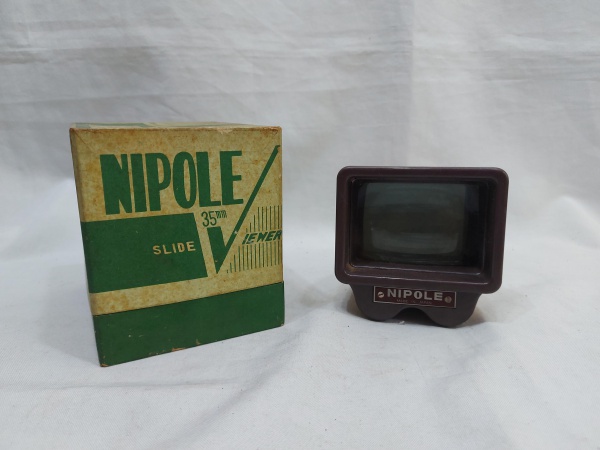 Projetor de Slides 35mm da Nipole, com corpo em baquelite. Medindo 9,5cm x 9,5cm x 12cm de comprimento. Não testado.