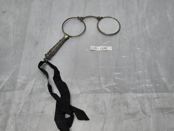 Lorgnon (ou lorgnette) antigo, um tipo de óculos de leitura portátil do século XIX ou início do século XX, em metal. Medindo 10,5cm de comprimento fechado. Falta 1 lente.