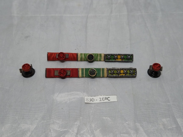 Conjunto militar composto por duas barretas de condecorações com passadores em fita e apliques metálicos, acompanhado por duas rosetas de lapela correspondentes. Medindo 11cm de comprimento.