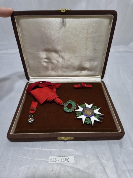 Conjunto da Ordem Nacional da Legião de Honra da República Francesa, composto por comenda de pescoço em metal esmaltado com fita vermelha original, miniatura e roseta de lapela, acondicionado em estoj