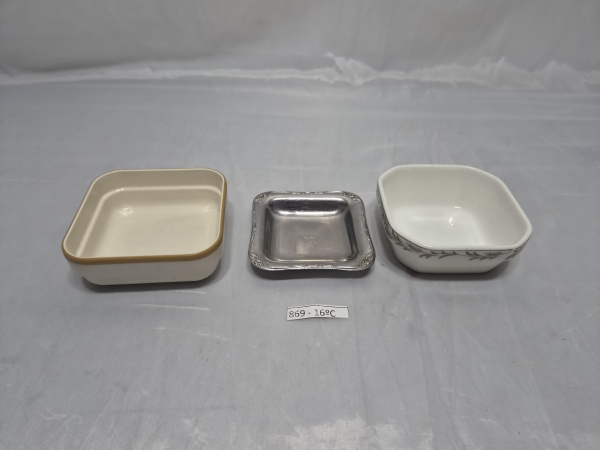 Lote de 3 manteigueiras da cia aérea Varig, sendo em porcelana, resina e inox. Medindo a de porcelana 8,5cm x 8,5cm x 3cm de altura.