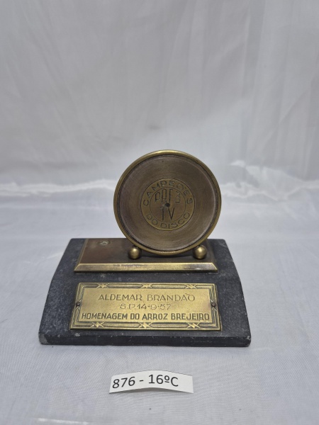 Troféu Homenagem "Campeões do Disco - PRF 3 TV" em bronze sobre base de mármore escuro, concedido a Aldemar Brandão por Arroz Brejeiro em 14 de setembro de 1957. Medindo 9,5cm x 7cm x 8cm de altura.