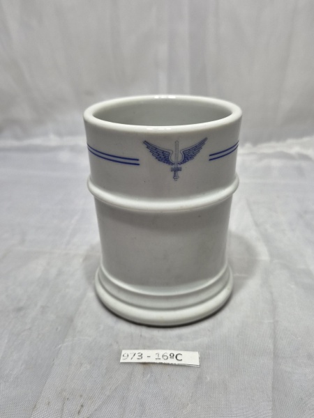 Copo em porcelana branca Rio Branco com decoração de frisos azuis e insígnia da Força Aérea Brasileira (FAB). Medindo 7,5cm x 10cm de altura