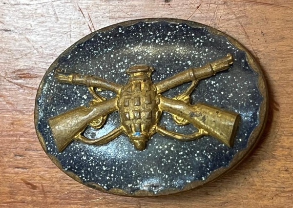 Broche do emblema ou insígnia de gola da arma de Infantaria do Exército Brasileiro, datado aproximadamente das décadas de 1930 ou 1940.
