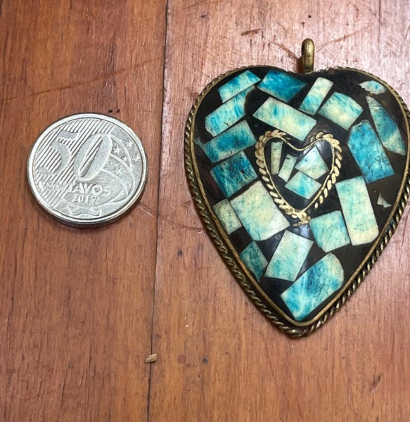 Pingente clássico de artesanato de estilo boho/tibetano, apresentando uma base metálica estruturada com incrustações em mosaico azul e turquesa feitas de resina ou lascas de pedras.