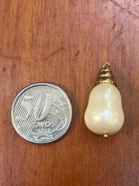 Pingente de pérola em formato de gota (ou pera) com acabamento superior de metal dourado estruturado em camadas.