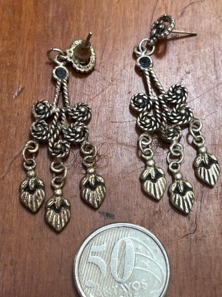 Brincos pendentes apresentam uma estética boho-chic vintage com acabamento em prata.