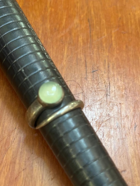 Anel em prata de lei solitário vintage com uma pedra central leitosa em formato de cabochão redondo.