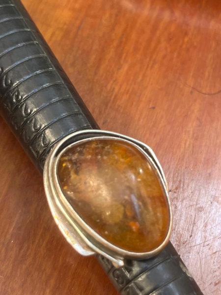 Anel antigo em prata de lei 925 com âmbar natural, destacando uma expressiva pedra em lapidação oval e tonalidades quentes que revelam a beleza única. Uma joia de época, elegante e atemporal, que une