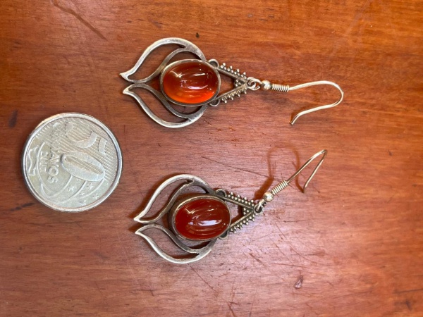 Par de brincos em prata de lei com acabamento envelhecido, inspirados na estética boho e na joalheria tradicional indiana. Adornados por âmbar natural em delicado tom mel translúcido, destacam-se pela
