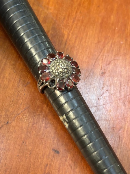 Anel de coquetel vintage de prata de lei 925 com pedras de granada e marcassita. O design apresenta uma composição floral ou em formato de chuveiro.