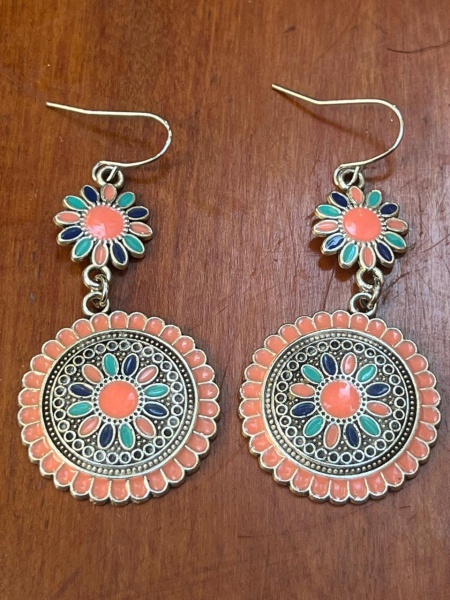 Brincos pendentes de estilo boho-chic. Eles trazem um design vintage com temática floral e detalhes geométricos esmaltados.