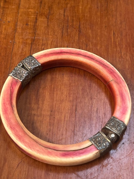 Bracelete ou pulseira escrava vintage de origem nômade/étnica, tradicionalmente confeccionada em marfim ou osso patinado com tonalidade avermelhada. A peça é composta por dois arcos semirrígidos unido