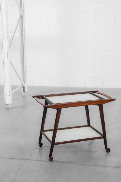 Geraldo de Barros - 1960 - Carrinho de bebidas executado em caviúna, em dois estágios, com tampos em laminado melamínico branco, sendo o superior removível como bandeja. 85 x 46 x 63cm de altura.