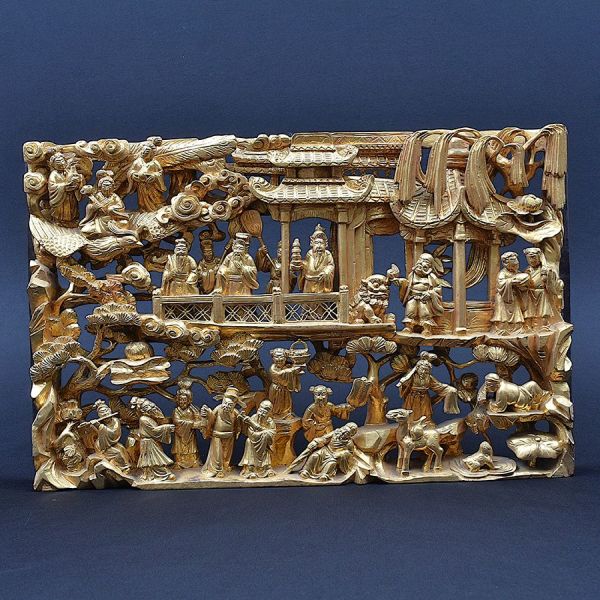 Talha em madeira entalhada e folheada a ouro, no estilo dos tradicionais painéis decorativos chineses de Chaozhou/Cantão (arte conhecida como `gold gilt wood carving`), profusamente esculpido em relev