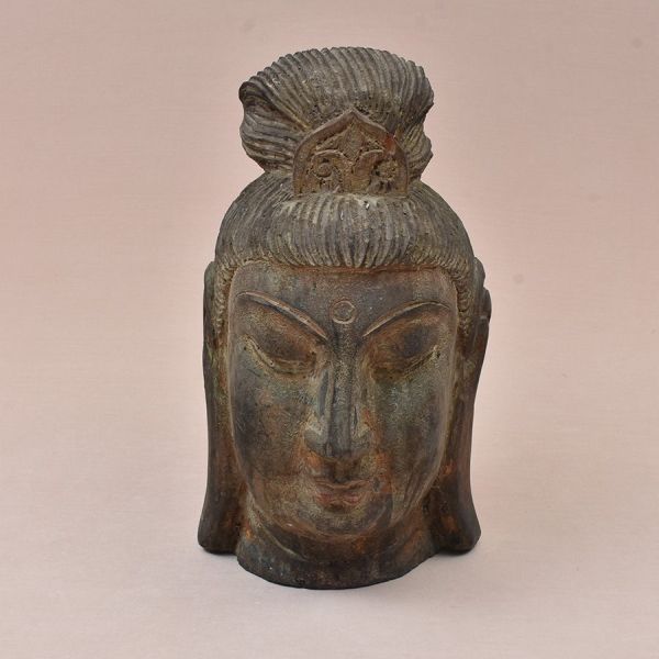 Cabeça de grande porte, esculpida em madeira maciça, representando o Buda em expressão de profunda serenidade meditativa — olhos semicerrados voltados para baixo, sobrancelhas em arco alongado, nariz