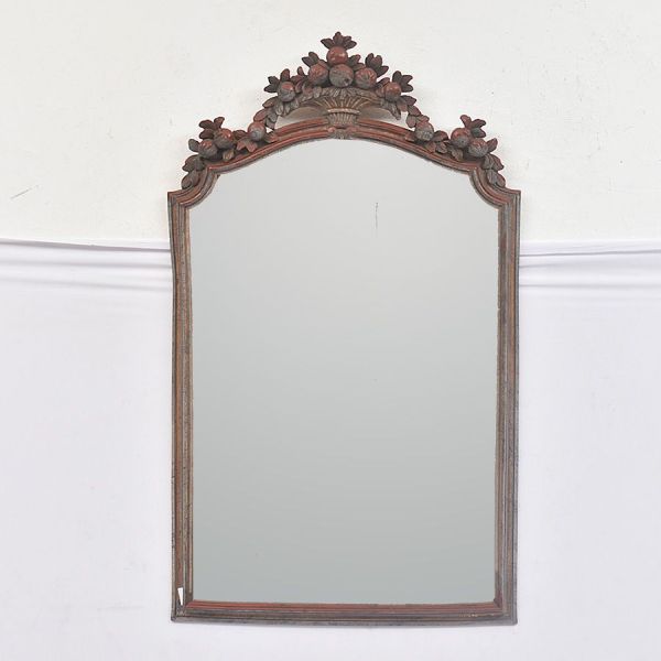 Espelho de moldura em madeira entalhada e dourada (com policromia parcial em tons de vermelho/bordô), moldura de perfil recortado e cimalha superior encimada por elemento decorativo em forma de cesto