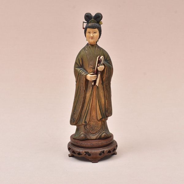 Escultura chinesa em marfim e bronze, representando figura da corte. Cabeça e mãos entalhadas em marfim — rosto sereno, penteado elaborado , enquanto o manto talar é executado em bronze trabalhado em 