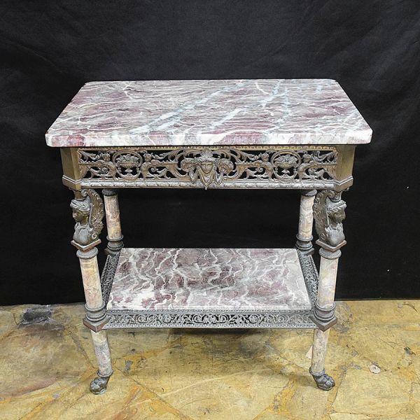 Mesa de encostar de bronze e mármore francesa do sec. XIX. Estrutura em bronze patinado, com tampo superior de perfil recortado nos cantos e prateleira inferior, ambos em mármore de veios rosados e ac