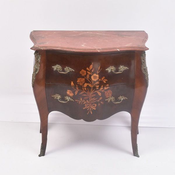 Cômoda francesa bombê, executada em madeira nobre com fino trabalho de marqueterie floral, apresentando frente e laterais curvas de elegante desenho rococó. Possui duas amplas gavetas adornadas por de