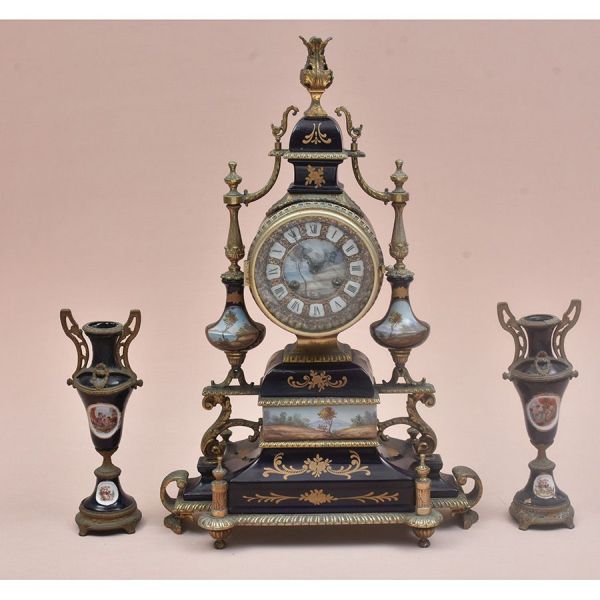 Terno (garniture de cheminée) francês composto por relógio de mesa central e par de ânforas/vasos, em porcelana estilo Sèvres com montagem em bronze dourado. A porcelana apresenta fundo azul cobalto c
