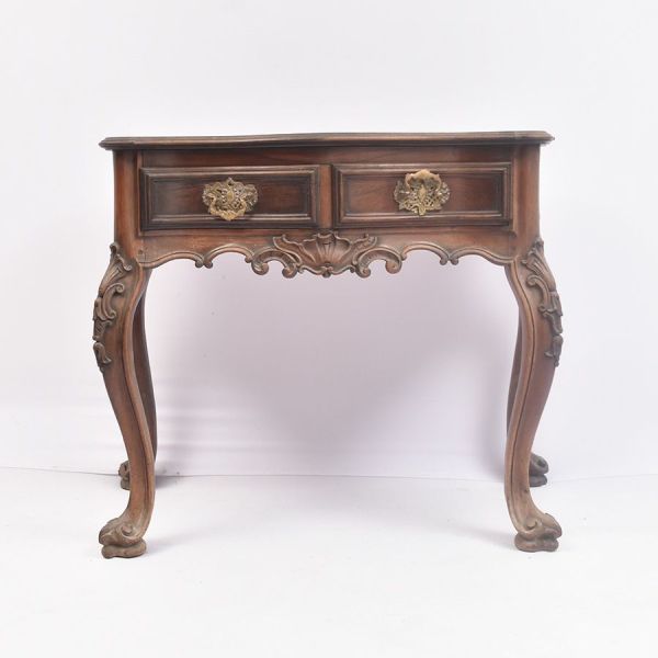 Mesa de encostar estilo D. José I, em jacarandá, sec. XIX. Apresentando elegante desenho de influência rococó. O tampo recortado de linhas sinuosas acompanha a movimentação da cintura, ricamente ornam