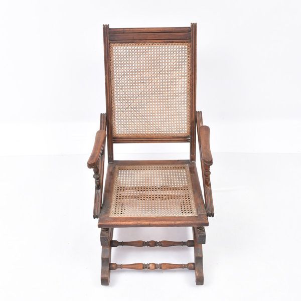 Cadeira de balanço modelo `americana` (platform rocker), em madeira nobre torneada. Peça montada sobre uma base fixa (`plataforma`) com mecanismo de molas de aço visíveis sob o assento, que permitem o