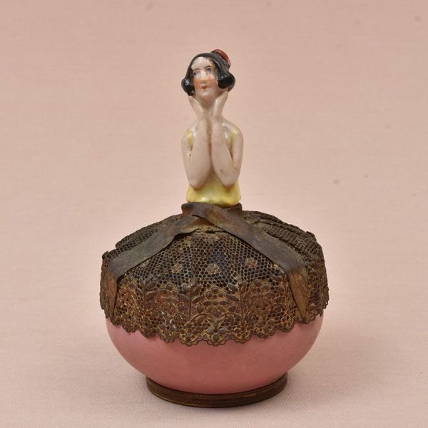 Porta-joias em porcelana francesa de Sèvres de formato circular em porcelana esmaltada na tonalidade rosa, guarnecido por montagens em metal dourado. Tampa articulada ornada por figura feminina em por