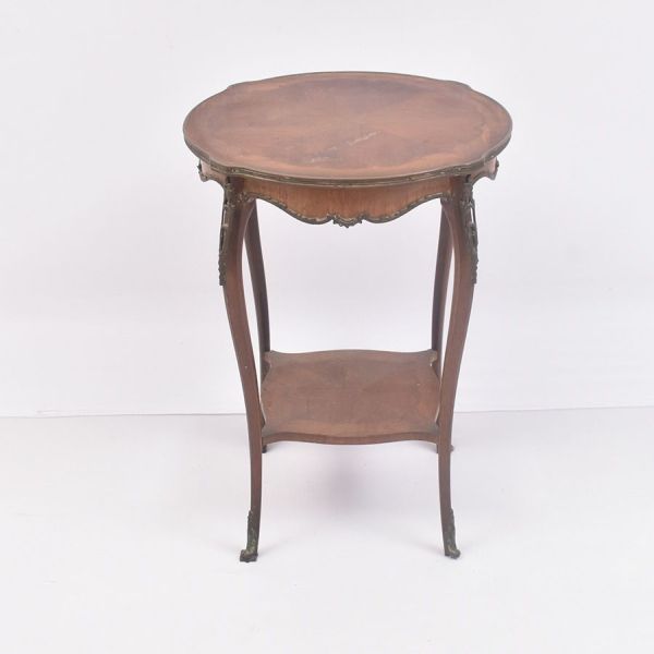 Mesa lateral francesa de estilo Louis XV, confeccionada em madeira nobre com delicadas aplicações em bronze dourado. Apresenta tampo recortado de contorno movimentado, seguindo a elegante tradição roc